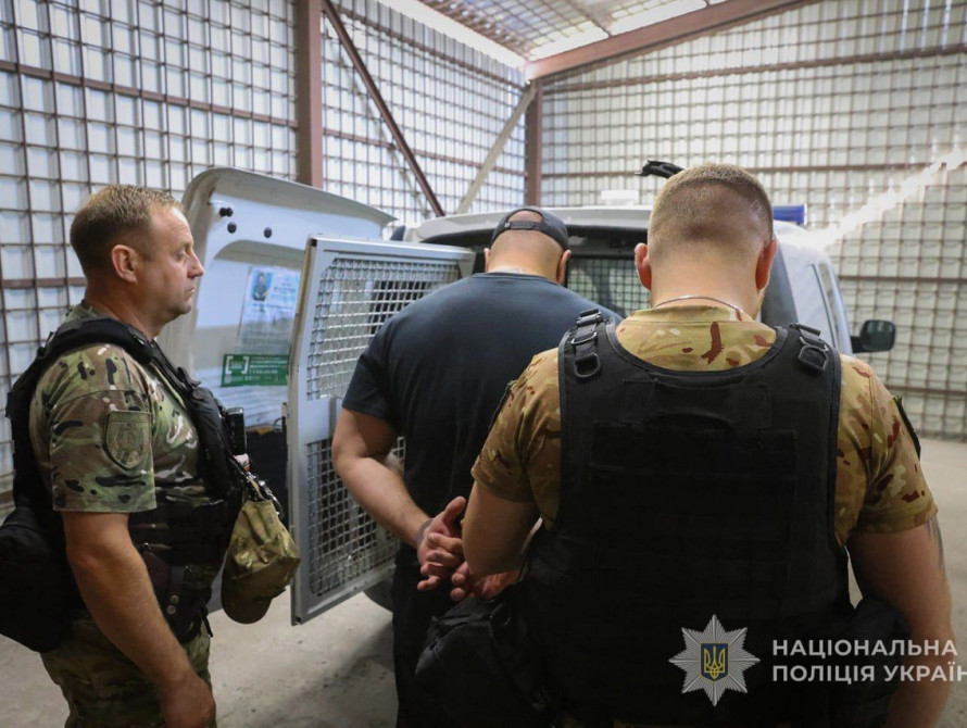 Затриманого чоловіка (підозрюваного у спробі вбивства) саджають в авто